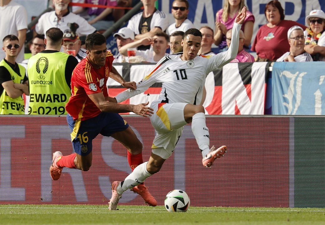 El español Rodri (I) y el alemán Jamal Musiala en acción durante el partido de cuartos de la Eurocopa 2024 entre España y Alemania en Stuttgart, Alemania EFE/EPA/RONALD WITTEK