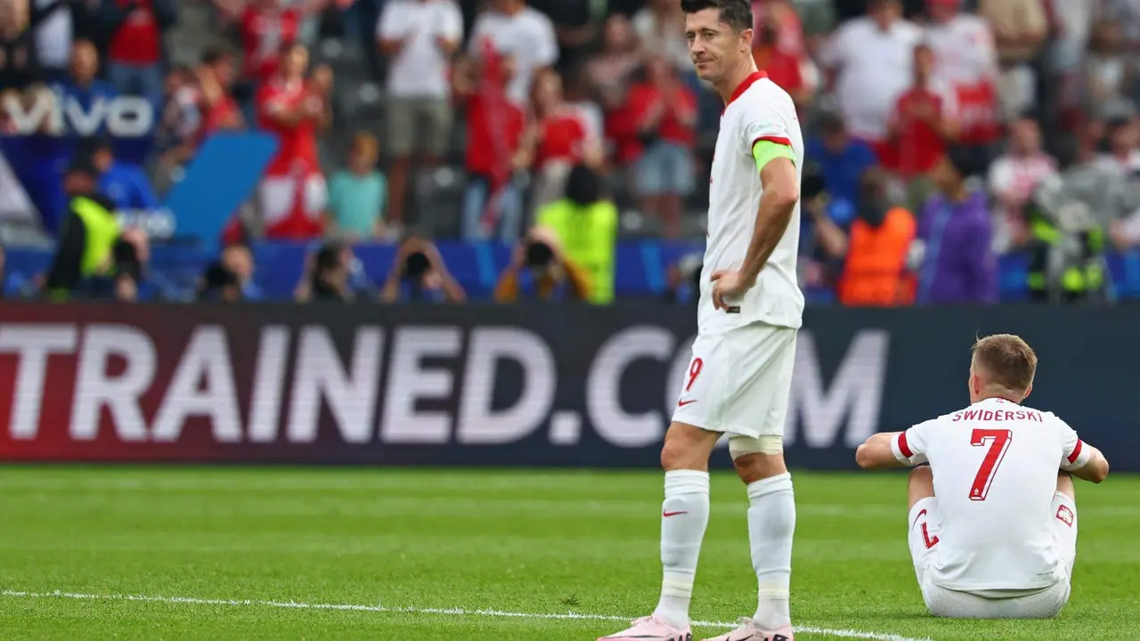 El delantero polaco Robert Lewandowski (I) y Karol Swiderski se lamentan tras la segunda derrota de Polonia en el torneo tras el partido del grupo D que han jugado Polonia y Austria en el Ol&iacute;mpico de Berl&iacute;n, Alemania. EFE/EPA/HANNIBAL HANSCHKE