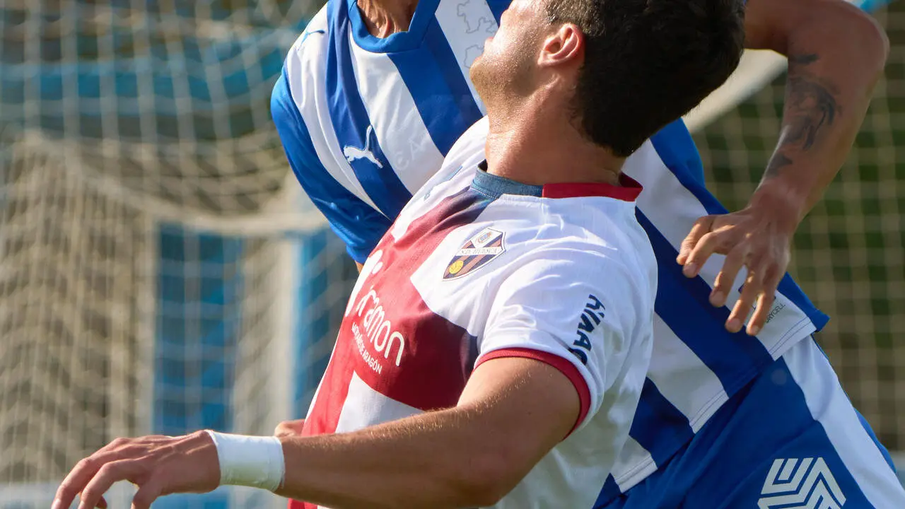 Javi Mier (delante), del Huesca, lucha por un bal&oacute;n alto con Nahuel Tenaglia, del Alav&eacute;s, durante el partido amistoso que Deportivo Alav&eacute;s y Huesca C.F. disputan este mi&eacute;rcoles en Vitoria. EFE/ ADRI&Aacute;N RUIZ HIERRO